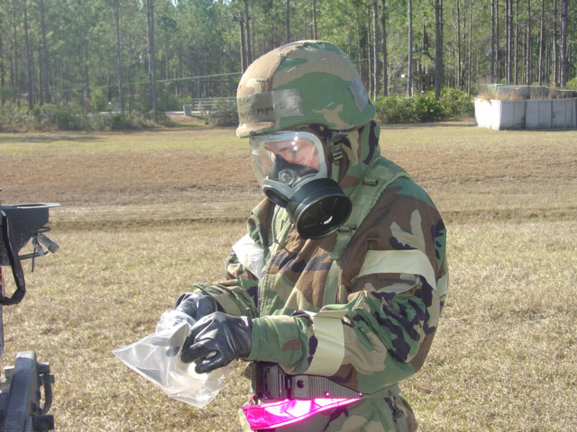 TYNDALL AIR FORCE BASE, Fla. - Airman 1st Class Margaret McGrane, 347th Civil Engineer Squadron Readiness Logistics apprentice, collects samples as part of a reconnaissance team, which checked for chemicals after an initial chemical attack during Silver Flag training at Tyndall Air Force Base, Fla. Forty-two Moody Airmen attended the five-and-a-half day deployment training. (Courtesy photo)                                 