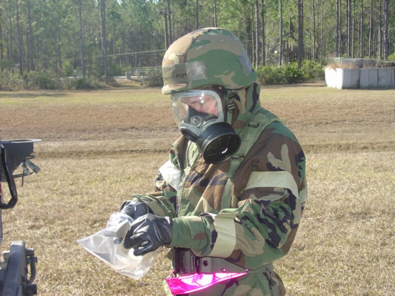 TYNDALL AIR FORCE BASE, Fla. - Airman 1st Class Margaret McGrane, 347th Civil Engineer Squadron Readiness Logistics apprentice, collects samples as part of a reconnaissance team, which checked for chemicals after an initial chemical attack during Silver Flag training at Tyndall Air Force Base, Fla. Forty-two Moody Airmen attended the five-and-a-half day deployment training. (Courtesy photo)                                 