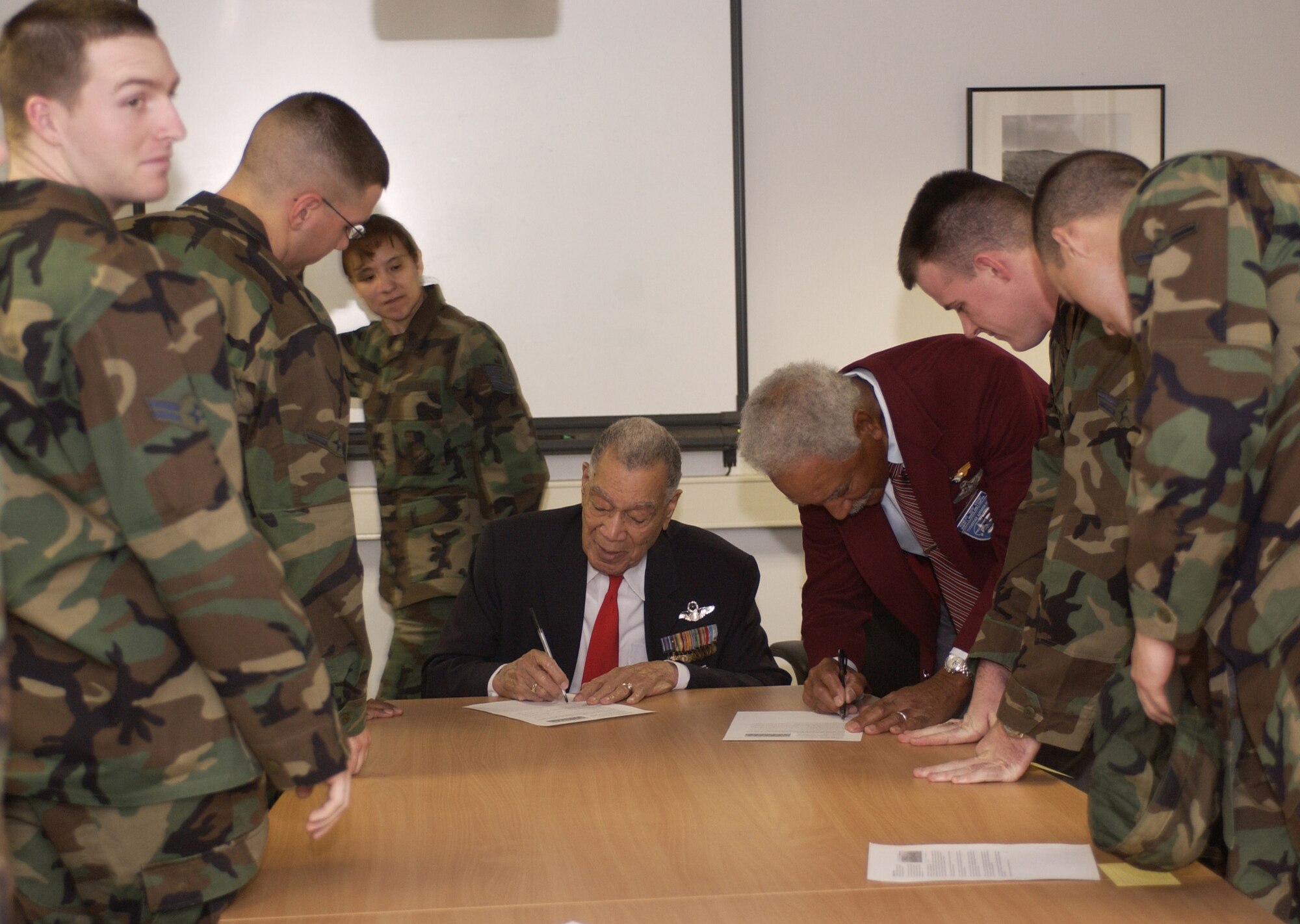SPANGDAHLEM AIR BASE, Germany (AFPN) -- Retired Lieutenant Colonels Lee Archer and Robert Ashby, members of the original Tuskegee Airmen, visit the first term Airman center to sign autographs. The Tuskegee Airmen visited the base Feb. 21 as part of the celebration of African-American History Month. (U.S. Air Force photo by Senior Airman Kristin Ruleau)

