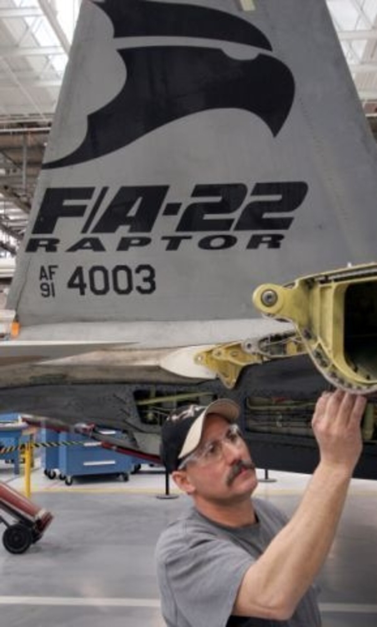 HILL AIR FORCE BASE, Utah - The 309th Aircraft Maintenance Group's Bret Hickenbotham, a 17-year aircraft structural mechanic, identifies various areas on the F-22 Raptor trainer here that will be affected by a modification for night, air-to-air refueling, while also inspecting its structural integrity. (Air Force photo by G. A. Volb)

