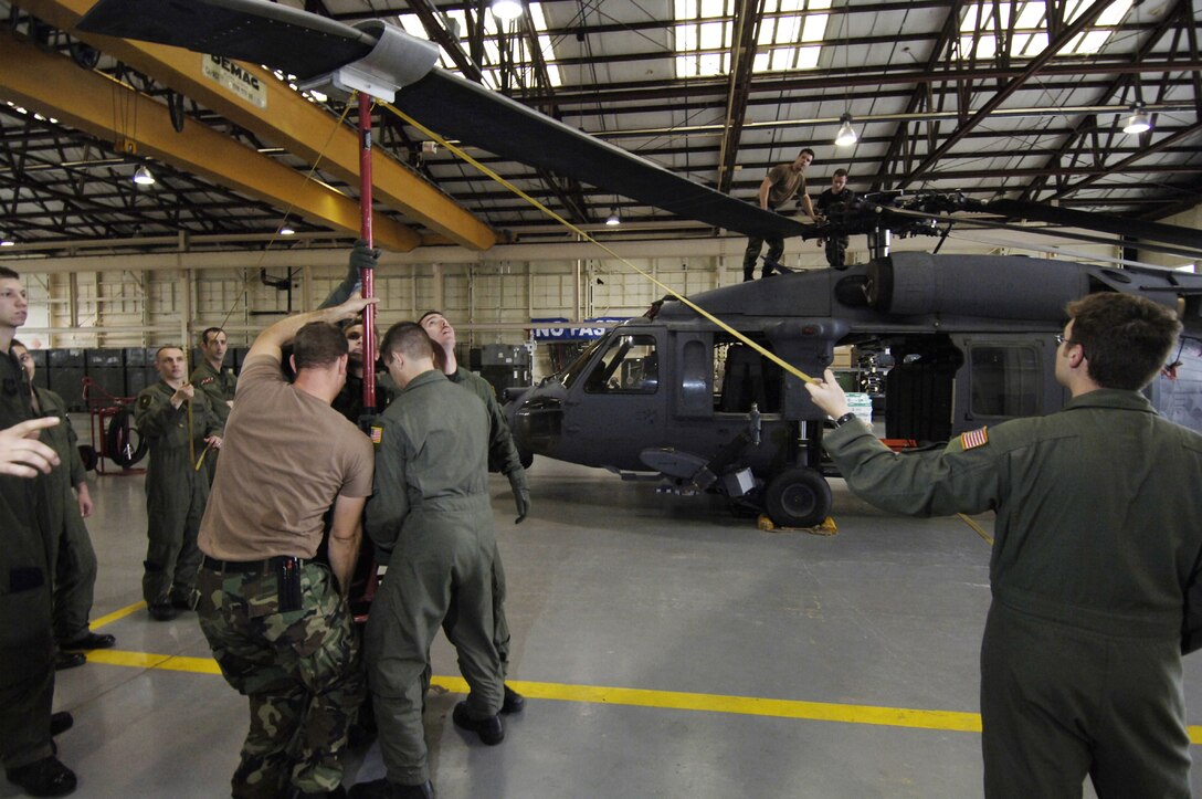 MOODY AIR FORCE BASE, Ga. -- Aircrew members from the 41st Rescue Squadron, here, learn specific operations for unfolding the main rotor blades of an HH-60G Pave Hawk from members of the 347th Aircraft Maintenance Squadron. This team effort will allow the crews rapidly deploy the helicopters. (Photo by Staff Sgt. Manuel Martinez)