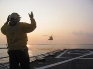 PENSACOLA BAY, Fla. - An HH-60G Pave Hawk, from the 41st Rescue Squadron at Moody Air Force Base, Ga., is guided into the Baylander, a Navy vessel used for helicopter training, during ship boarding operations Jan. 25 and 26 here. (Photo by Tech. Sgt. Mark Riensche)
