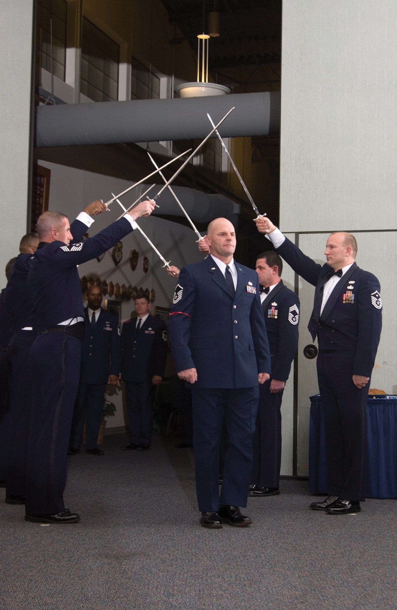 Master Sgt. Dwayne Moore, 512th Civil Engineer Squadron, was one of 23 Liberty Wing members inducted into the senior noncommissioned officer corps Feb. 4 at The Landings, Dover Air Force Base, Del. Chief Master Sgt. Patrick Ferrell (left), 22nd Air Force civil engineer manager, Dobbins Air Reserve Base, Ga., and Master Sgt. Louis Klaus (right), 512th Civil Engineer Squadron first sergeant, present an honor cordon for the inductees.