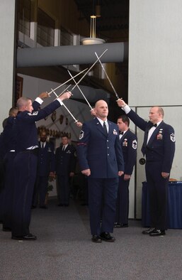 Master Sgt. Dwayne Moore, 512th Civil Engineer Squadron, was one of 23 Liberty Wing members inducted into the senior noncommissioned officer corps Feb. 4 at The Landings, Dover Air Force Base, Del. Chief Master Sgt. Patrick Ferrell (left), 22nd Air Force civil engineer manager, Dobbins Air Reserve Base, Ga., and Master Sgt. Louis Klaus (right), 512th Civil Engineer Squadron first sergeant, present an honor cordon for the inductees.