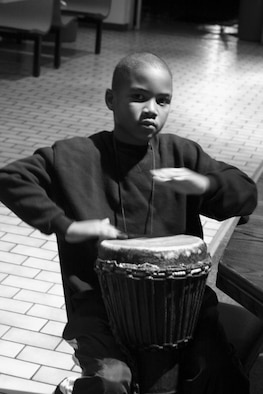 A child plays the drums during the African American heritage Airmen's Night Out in the community center Wednesday.