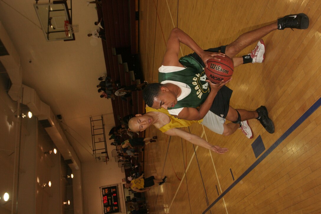 Jeff Frank, Headquarters Battalion Team 1, makes a quick pass away from Eric Cooke, 1st Tank Battalion.