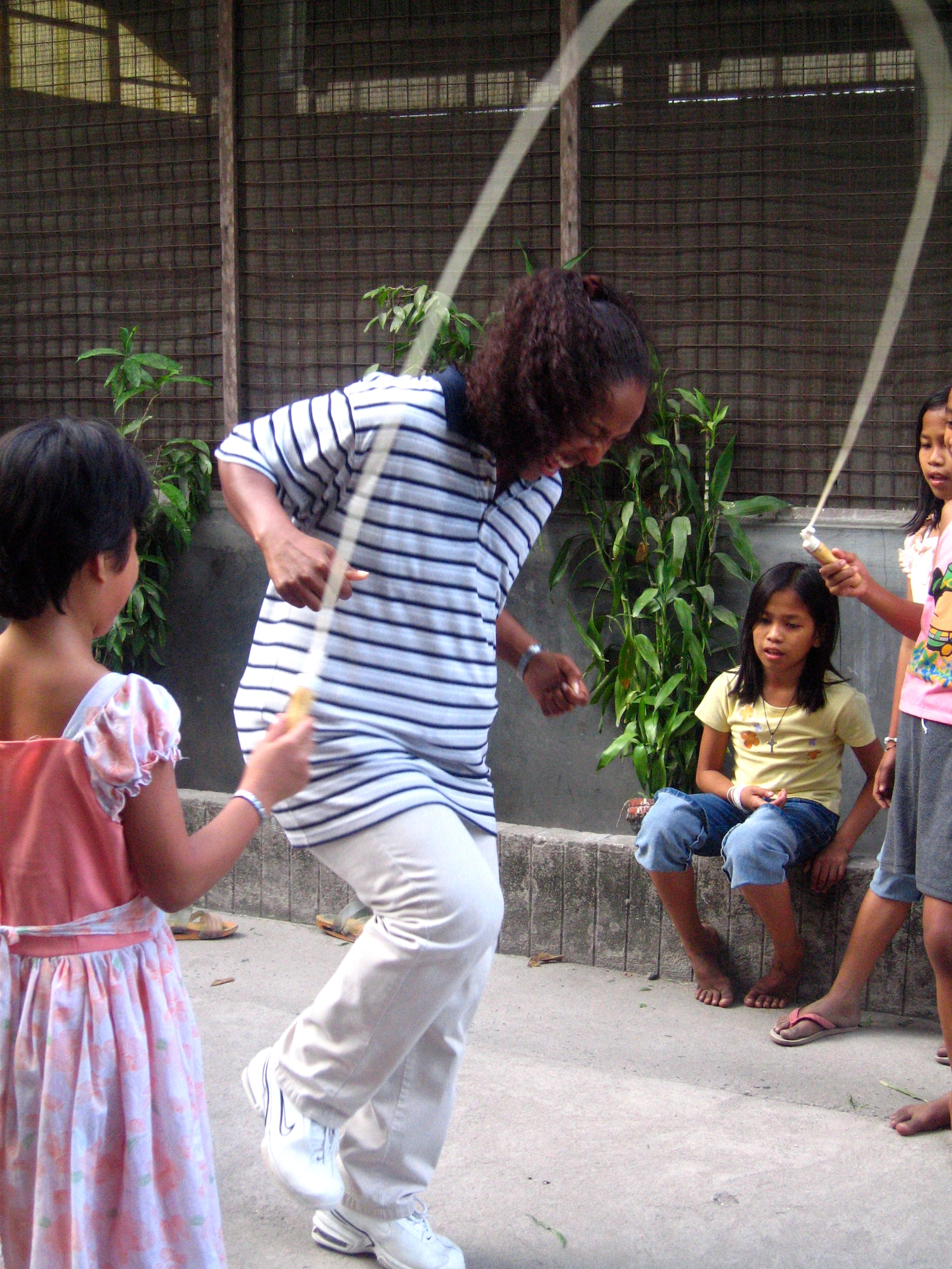 Capt. Tiaundra Sorrell jumps rope with some of her new friends from the Children's Home of the Immaculate Heart of Mary in Angeles City, Philippines, Sunday, Feb. 26, 2006. The captain is deployed from the 36th Air Base Wing, Anderson Air Force Base, Guam. She and other servicemembers visited the home to bring cheer and gifts. The home is for abandoned girls from the ages of 6 to 16. (U.S. Air Force photo/Capt. Ben Alumbaugh)