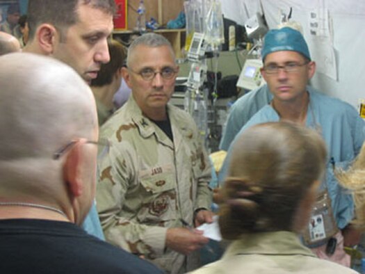 Dr. (Col.) Renee Jaso, commander or the Air Force Reserve's 433rd Medical Squadron (center), receives a briefing about the condition of an ICU patient in the AFTH.  Colonel Jaso volunteered, for the second time, to step away from his successful general surgury practice in San Antonio to help heal servicemembers in Iraq. "The real heroes are those who defend our liberty with their flesh and bones," said Colonel Jaso. "All I can do in return is take care of them when they fall."