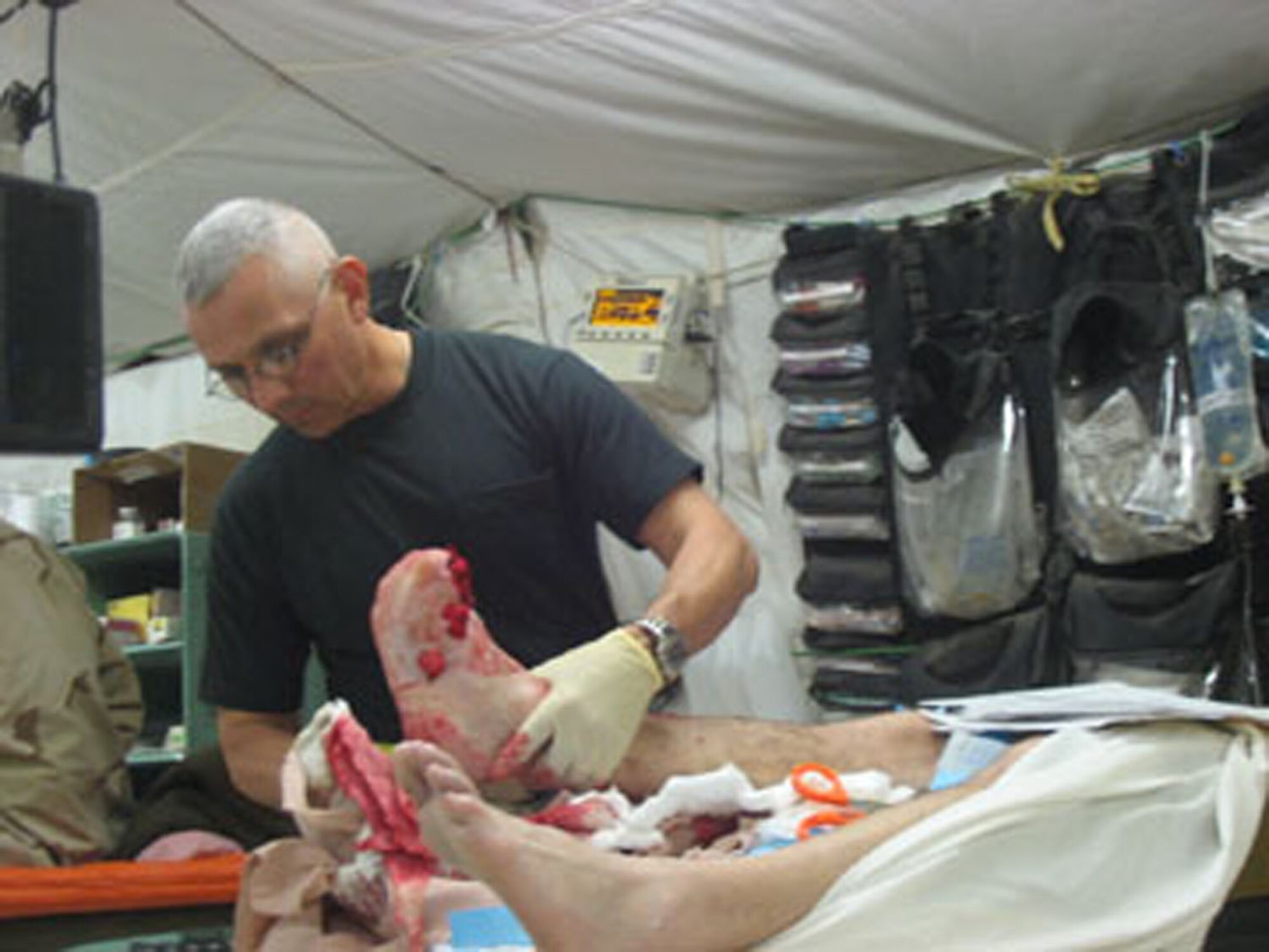 Dr. (Col.) Jaso, a surgeon with the 433rd Medical Squadron, tends to the urgent wounds of an Army member in the  emergency room of the AFTH, Balad, Iraq. Col. Jaso is an Air Force reservist serving his second volunteer term as a general surgeon in Iraq.