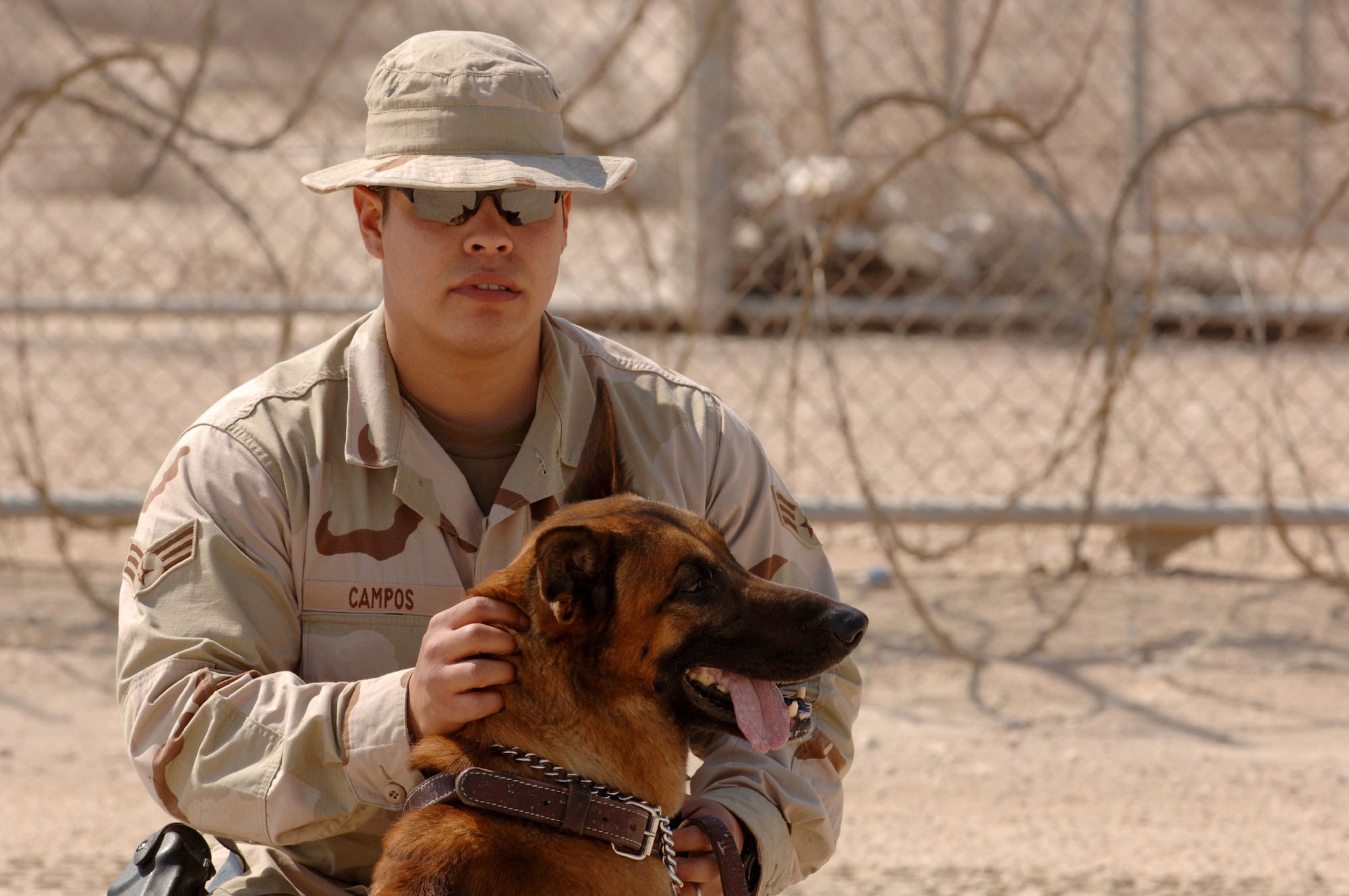 SOUTHWEST ASIA (AFPN) -- Senior Airman Martin Campos pets his military working dog, Rico, at a deployed location Feb. 24. Airman Campos and Rico, a Belgian Malinois, are with the 379th Expeditionary Security Forces Squadron. (U.S. Air Force photo by Staff Sgt. Joshua Strang) 