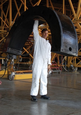 433rd Airlift Wing reservist, Tech. Sgt. David Alsip, demonstrates how light the new C-5 maintenance stand is. Despite its lack of heft, the stand is solid and helps disperse the maintainer's weight, putting less stress on the engine cowling. The engine stand was designed and developed by Sergeant Alsip and the rest of the 433rd fabrication shop. The stand was certified for use in late October 2005. (Photo by Staff Sgt. Bethaney Trapp)