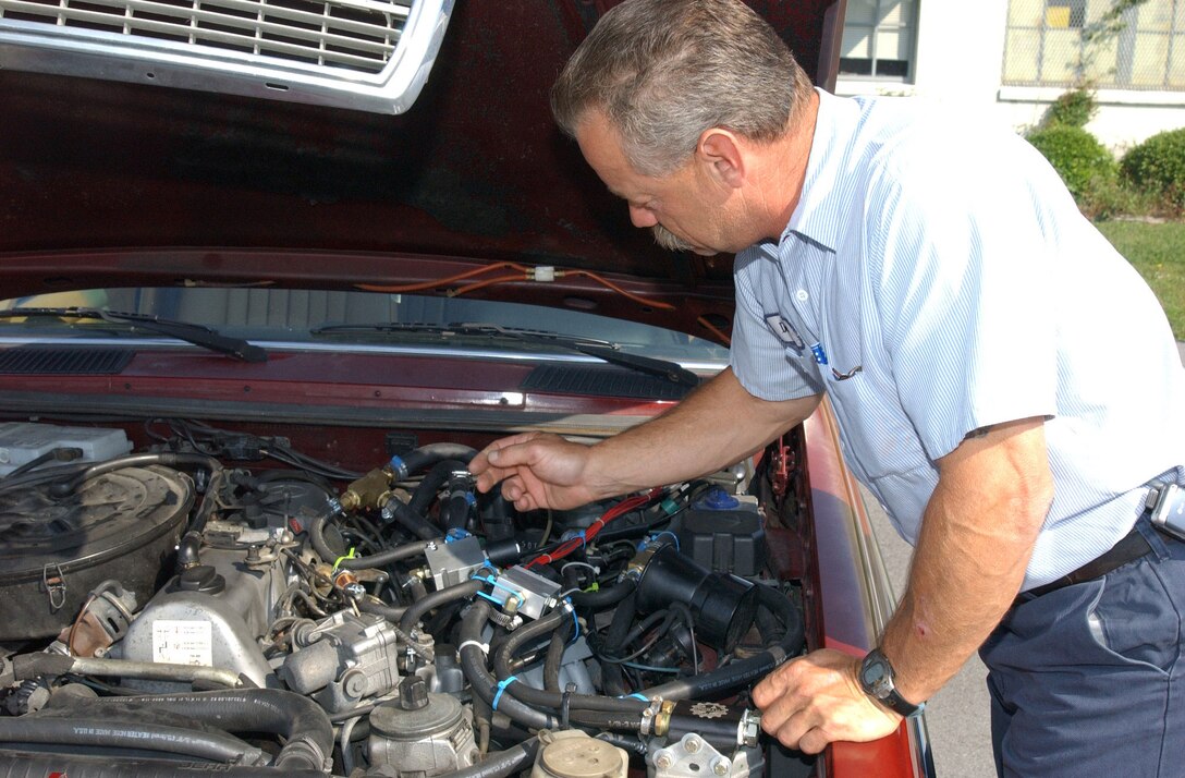 Retired Master Sgt. David Flint, who now works with Marine Corps Base Motor Transportation, adjusts the system that allows his vehicle to run on vegetable oil.