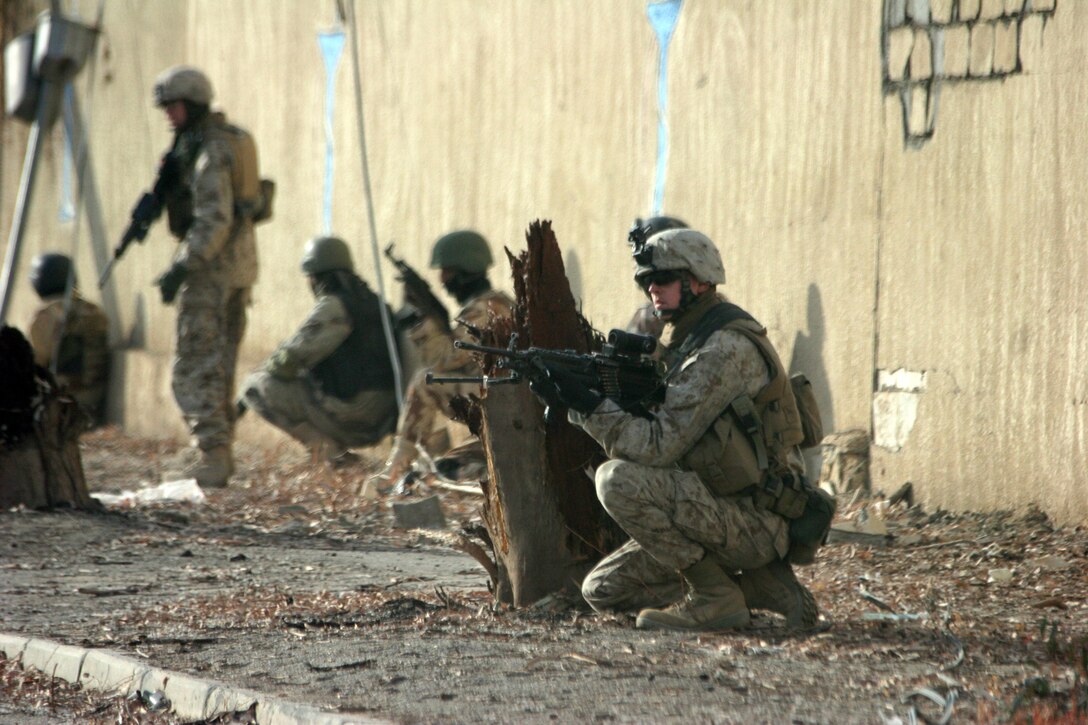 AR RAMADI, IRAQ (January 2, 2006) – A Marine stands guard while medical supplies are delivered to a local clinic during a 6th Civil Affairs Group humanitarian aid mission Jan 2. Photo by Cpl. Shane Suzuki