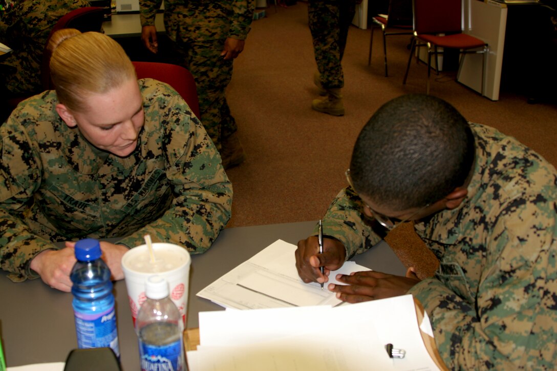 Lance Cpl. Christine Traue, an administration clerk, helps Pfc. Michael King from Marine Aircraft Group 14 correct inconsistencies in his SRB.