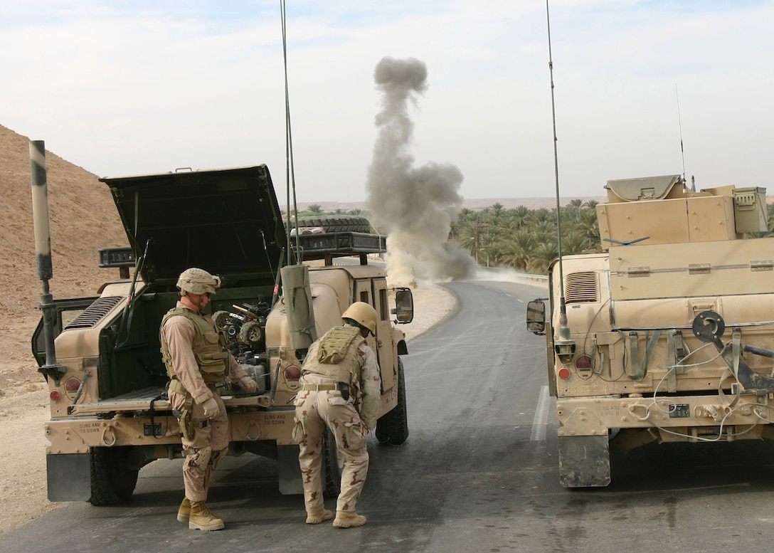 Members of a Navy and Marine Explosive Ordnance Disposal (EOD) supporting a patrol from Battalion Landing Team 1st Bn., 2nd Marines take cover behind their Humvee as they destroy an improvised explosive device near Forward Operating Base Hit, Iraq, Jan. 2, 2006.  The patrol, which is part of the ground combat of the 22nd Marine Expeditionary Unit (Special Operations Capable), moments earlier discovered the IED and also engaged and destroyed an insurgent IED placement team as part of the MEU's ongoing counterinsurgency efforts in Iraq's Al Anbar province with the 2nd Marine Division.