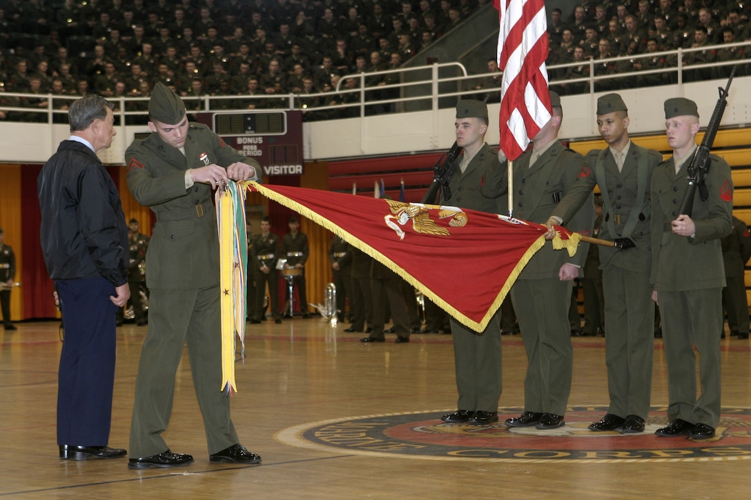A Marine within the 2nd Marine Division replaces his battalion?s battle streamer onto the division?s battle colors during a battle colors rededication ceremony here Feb. 3.  Members of the 2nd Marine Division Association were on hand Feb. 2-3 to help commemorate the 65th birthday of the ?Follow Me? division and pay their respects to fallen warriors past and present.