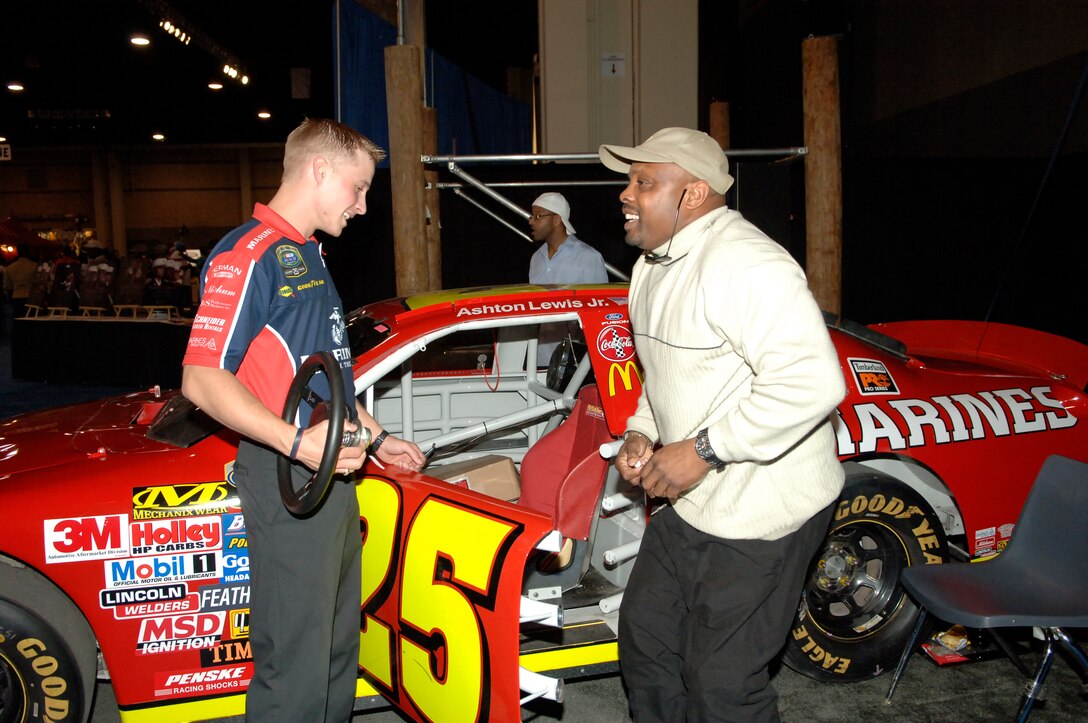 Show car driver, Kevin Williams, left talks with James Wright from Hampton, Va., during the 61st Annual CIAA tournament.  The show car featured a racing simulator where participants were able to experience driving a race car.