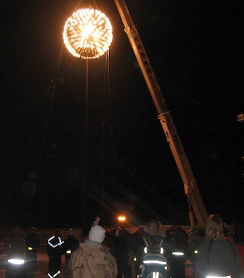 SOUTHWEST ASIA (AFPN) -- A 2,000-pound New Year's Eve Ball lights up the sky over this desert base. The ball, sculpted from a sewage tank, was the work of 379th Expeditionary Civil Engineering Squadron. They built it in about 72 hours. It was suspended approximately 100 feet in the air and lowered from a crane as the crowd counted down the seconds until 2006. (U.S. Air Force photo)