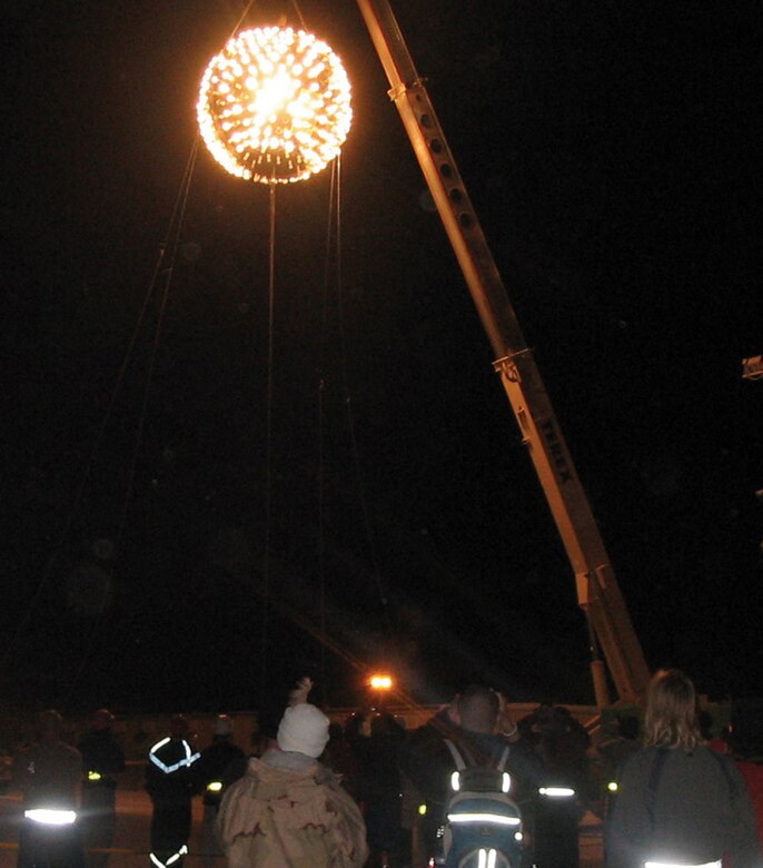 SOUTHWEST ASIA (AFPN) -- A 2,000-pound New Year's Eve Ball lights up the sky over this desert base. The ball, sculpted from a sewage tank, was the work of 379th Expeditionary Civil Engineering Squadron. They built it in about 72 hours. It was suspended approximately 100 feet in the air and lowered from a crane as the crowd counted down the seconds until 2006. (U.S. Air Force photo)