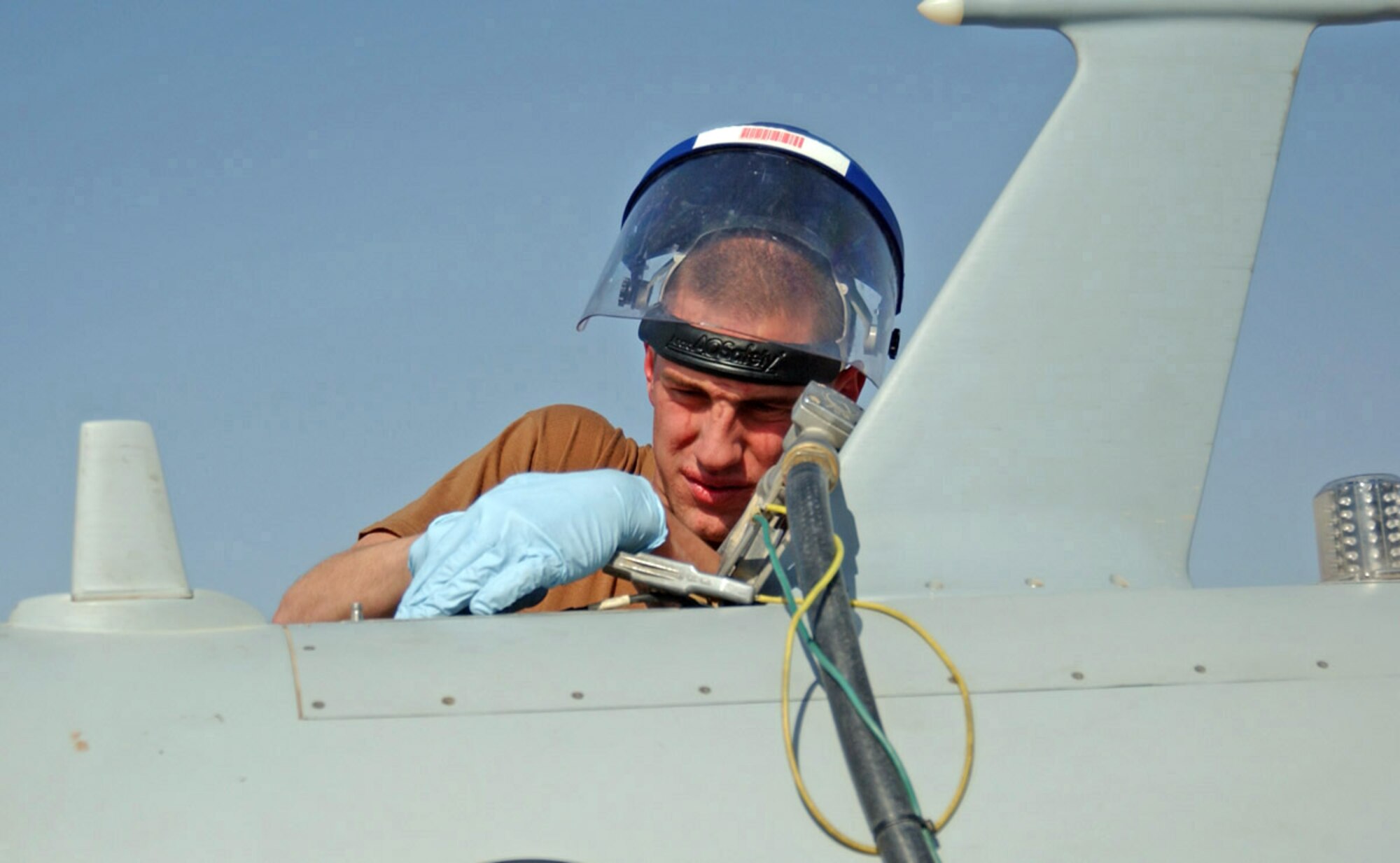 BALAD AIR BASE, Iraq (AFPN) -- Senior Airman Chris Thompson gets ready to refuel an MQ-1 Predator before a mission. The Airman is with the 46th Aircraft Maintenance Unit and deployed from Creech Air Force Base, Nev. (U.S. Air Force photo by Staff Sgt. Tammie Moore)