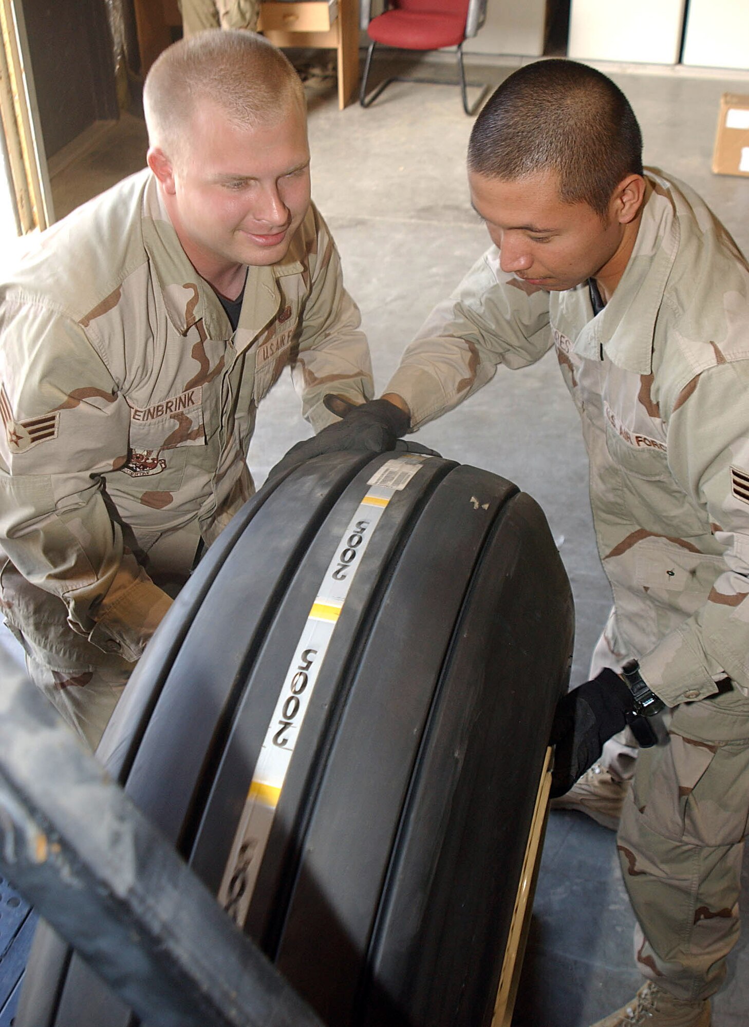 Senior Airman Isaiah, left, and Senior Airman Jameson Flores replace a tire on a KC-135 Stratotanker's main landing gear in the 380th Expeditionary Logistics Readiness Squadron's flightline supply shop. The Airmen are deployed from the 62nd Logistics Readiness Squadron at McChord Air Force Base, Wash. (U.S. Air Force photo/Tech. Sgt. Mike Hammond)