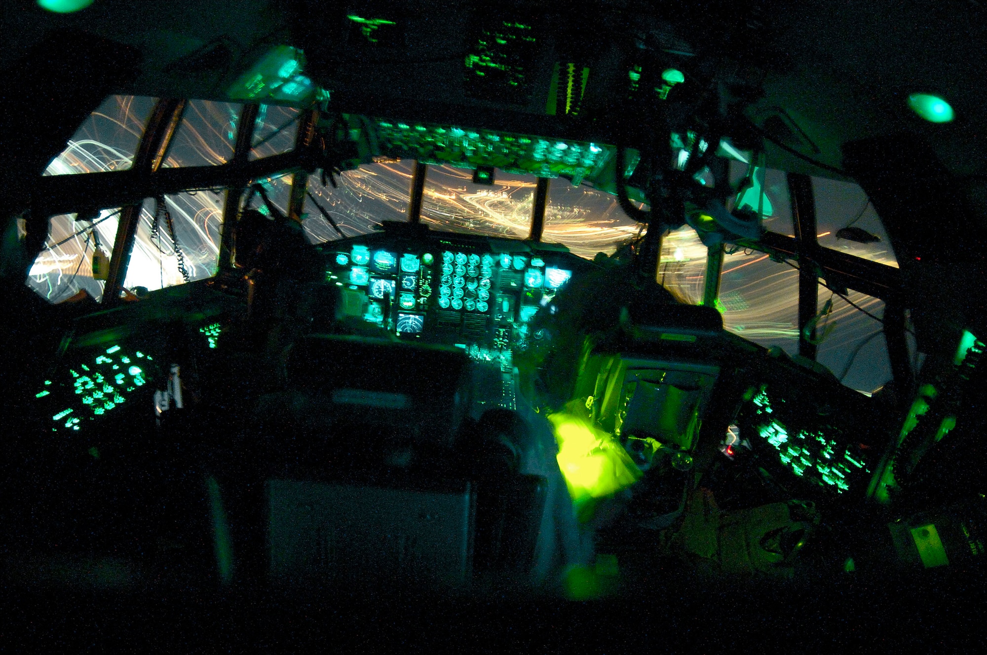 OVER BALAD AIR BASE, Iraq (AFPN) -- In the shadows of their C-130 Hercules' flight deck, (left to right) pilot Maj. Mike Wilson, flight engineer Senior Master Sgt. Ernie Leyba and co-pilot Capt. Tim Pemberton approach for a landing at Balad Air Base. The crew flew a New Year's Eve mission to deliver 13 passengers and 13,000 pounds of cargo -- landing at Balad in 2006. Members of the Air Force Reserve Command's 731st Airlift Squadron, the crew is ending a Southwest Asia tour with the 746th Expeditionary Airlift Squadron. (U.S. Air Force photo by Master Sgt. Lance Cheung)