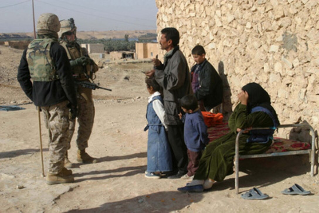 U.S. Marines 1st Lt. Kyle Springs and Cpl. Steven Manner speak to an Iraqi man and his family about any insurgents in the area during a presence patrol in Kaffajiyah, Iraq, on Dec. 29, 2005. Springs and Manner are attached to Weapons Company, 3rd Battalion, 1st Marine Regiment. 