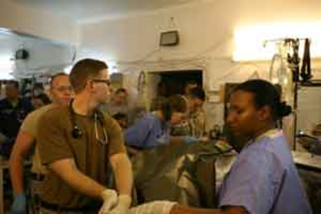 Army Capt. David M. Brennen, a field surgeon with the Charlie Medical unit at Camp Ramadi, leads a team of service members treating an Iraqi army soldier July 3, 2006. Charlie Medical is a joint medical center where U.S. Army and Navy medical personnel provide care for U.S. service members and Iraqis operating in and around the city of Ramadi and is one of the busiest trauma centers in Iraq.
