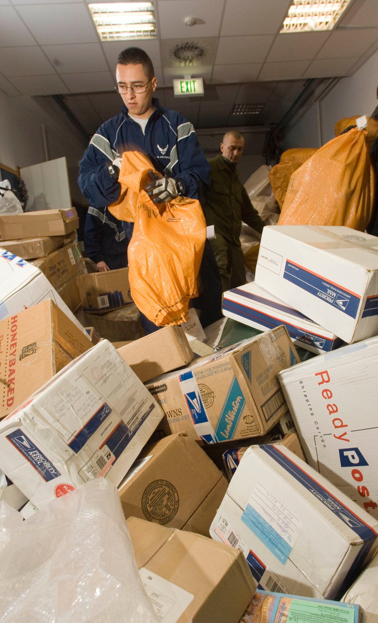 RAMSTEIN AIR BASE, Germany (AFPN) -- Airman 1st Class Will Coppedge empties bags of mail at the North Side Post Office. Although Christmas has past, packages are still arriving here. Airman Coppedge is a postal clerk with the 435th Communication Squadron. (U.S. Air Force photo by Master Sgt. John E. Lasky)
