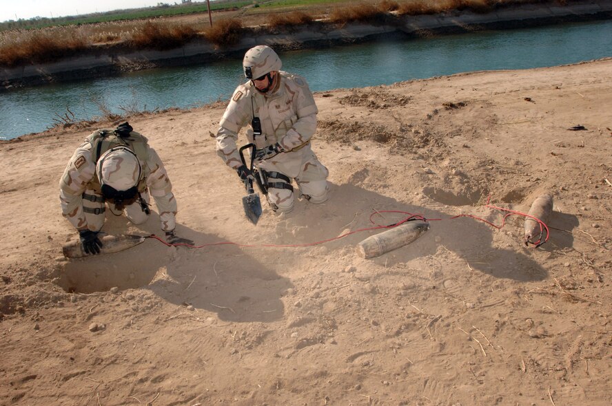 SHAKARIA, Iraq (AFPN) -- Capt. Joshua Tyler (left) and Tech. Sgt. Brian Schilhabel secure an improvised explosive device. The IED was found along a road during a search of the area near a village here. The device had a bar-pressure plate linked to three 122 mm artillery shells. The inspection was part of the search-and-sweep operations by Soldiers from Bravo Company, 2nd Battalion of the 502nd Infantry Regiment. Captain Tyler and Sergeant Schilhabel are with the 447th Expeditionary Civil Engineer Squadron explosive ordnance disposal flight. (U.S. Air Force photo by Army Staff Sgt. Kevin L. Moses Sr.)