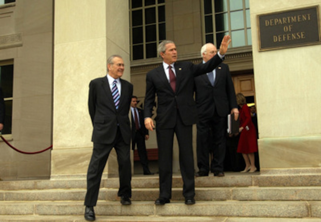 President George W. Bush waves to photographers as he comes down the steps at the Pentagon with Secretary of Defense Donald H. Rumsfeld (left) and Vice President Dick Cheney (obscured) on Jan. 4, 2006. Bush, Rumsfeld, Cheney, Secretary of State Condoleezza Rice, Chairman of the Joint Chiefs of Staff Gen. Peter Pace, U.S. Marine Corps, and Chief of Staff to the President Andrew Card were briefed by senior commanders in person and via secure video teleconference on the latest developments in Iraq, Afghanistan and the global war on terror. 