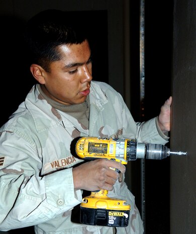 BAGRAM AIR BASE, Afghanistan (AFPN) -- Senior Airman Daniel Valencia hangs a sheet of drywall in the base's new passenger terminal.  Scheduled to open early this year, the 7,750-square-foot facility can handle 300 travelers.  Airman Valencia is from Cashmere, Wash. He is a structural journeyman with the 1st Expeditionary Red Horse Group deployed from Nellis Air Force Base, Nev. (U.S. Air Force photo by Staff Sgt. Marcus McDonald)