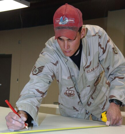 BAGRAM AIR BASE, Afghanistan (AFPN) -- Staff Sgt. Gregory Roger marks a sheet of drywall for a new passenger terminal construction project.  Scheduled to open early this year, the 7,750-square-foot facility can handle 300 travelers. Sergeant Roger is from Deer Park, N.Y. He is a structural craftsman with the 1st Expeditionary Red Horse Group deployed from Nellis Air Force Base, Nev. (U.S. Air Force photo by Staff Sgt. Marcus McDonald)
