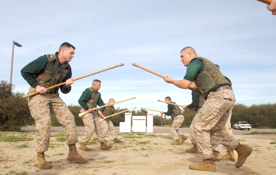 From left to right, Sgts. Brian A. Price and David G. Dobson, both drill instructors at Instructional Training Company, perform bayonet techniques with wooden practice rifles on the depot physical training field Tuesday.