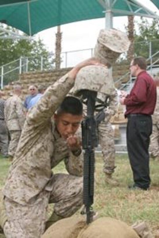 Lance Cpl. Jose L. Garcia, a Midland, Texas, native, kisses the dog tags of one of his fallen brothers at a memorial for seven Marines and one Navy corpsman from 3rd Light Armored Reconnaissance Battalion Oct. 6.