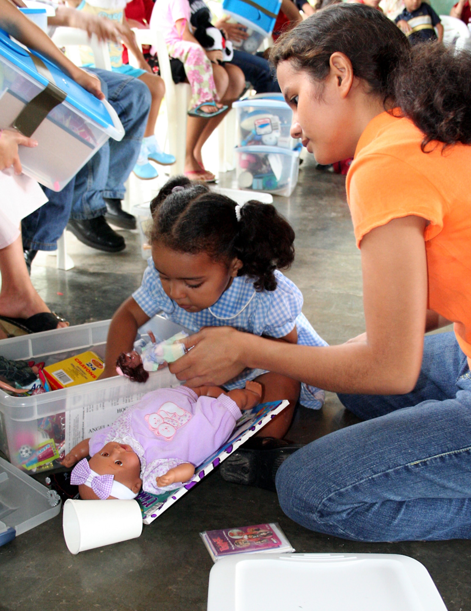 A young girl excitedly opens her box of goodies after receiving it from Santa Claus at Aldea Infantil SOS de La Ceiba, Honduras. (U.S. Air Force photo by Senior Airman Heidi Davis) 