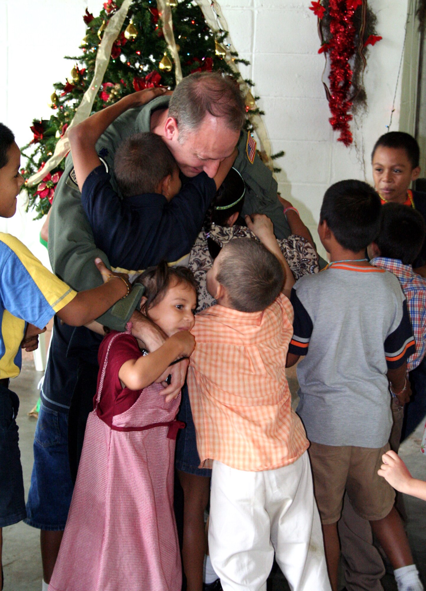 Lt. Col. Rob Toth, 15th SOS commander, is swarmed by children at Aldea Infantil Sos La Ceiba, Honduras. (U.S. Air Force photo by Senior Airman Heidi Davis)