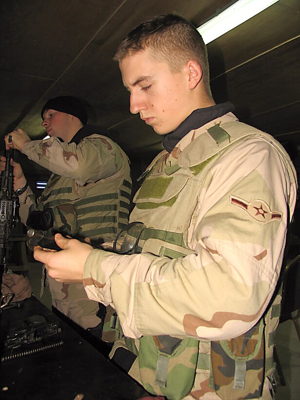 CAMP BUCCA, Iraq (AFPN) -- Gunner Airman Jason Taylor (front) and Airman 1st Class Lucas King clean their weapons during a shift break. They are part of the more than 300 Airmen of the 586th Expeditionary Security Forces Squadron. The unit provides base, convoy and area security here. The Airmen are deployed from Ellsworth Air Force Base, S.D. Airman Taylor is from Seattle and Airman King is from Painesville, Ohio. (U.S. Air Force photo)