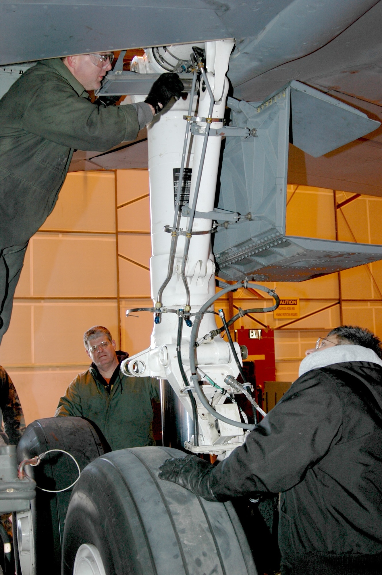 Tech. Sgt. Chris Rust (left) inserts a pin into a strut on a KC-135R Stratotanker as Tech. Sgt. Michael Gold (center) and Tech. Sgt. Dan Lecroy maneuver the strut into position.  All are members of the 434th Maintenance Group, Air Force Reserve Command, Grissom ARB, Ind.