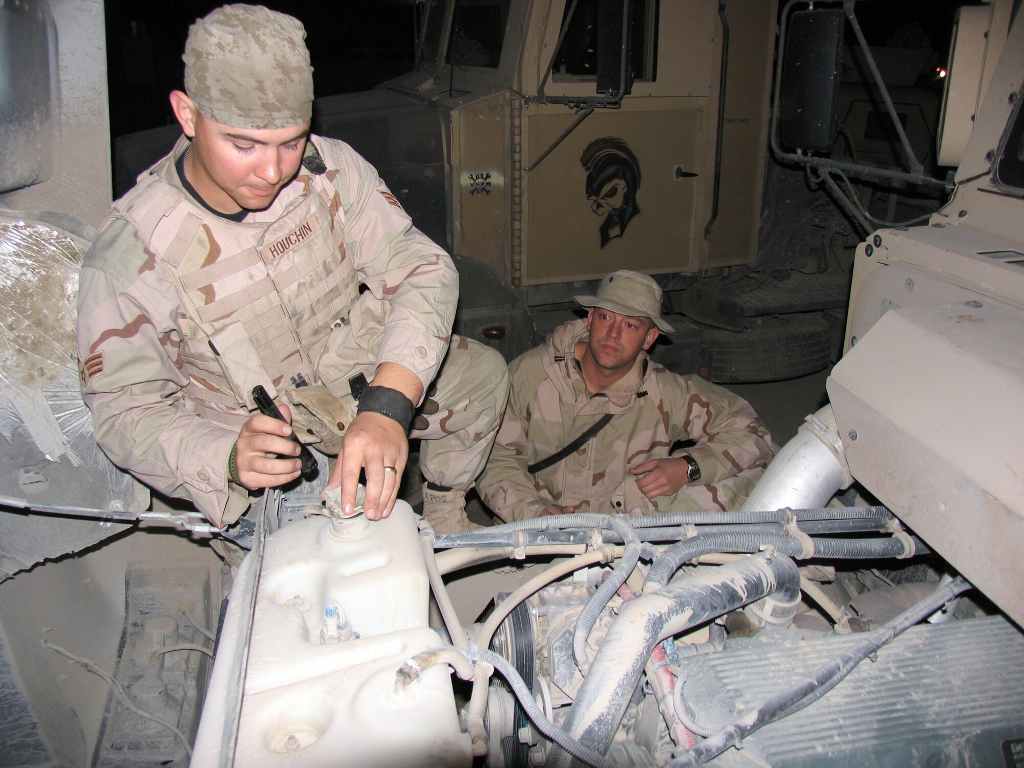 SOUTHWEST ASIA (AFPN) -- Vehicle operator Senior Airman William Houchin checks his truck's radiator fluid with help from convoy mechanic Staff Sgt. Anthony Salas. (U.S. Air Force photo by Staff Sgt. Scott Campbell)