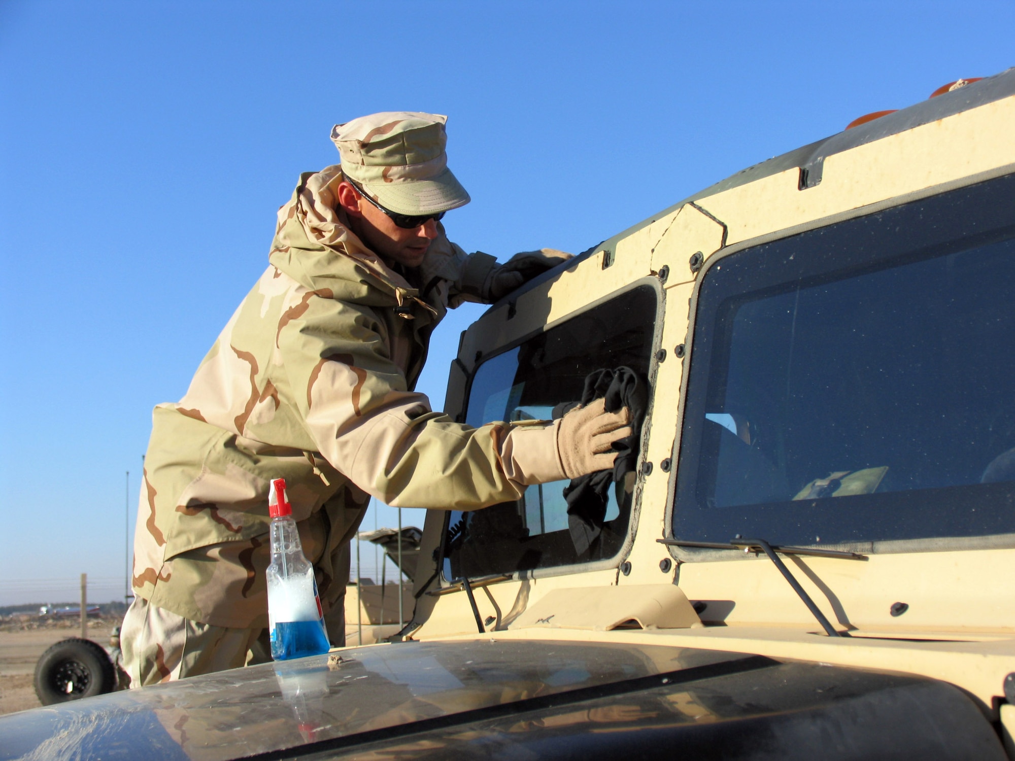 SOUTHWEST ASIA (AFPN) -- Convoy commander Tech. Sgt. Bill Bellmore cleans the windows of his truck before getting his convoy back on the road to Iraq.  (U.S. Air Force photo by Staff Sgt. Scott Campbell)