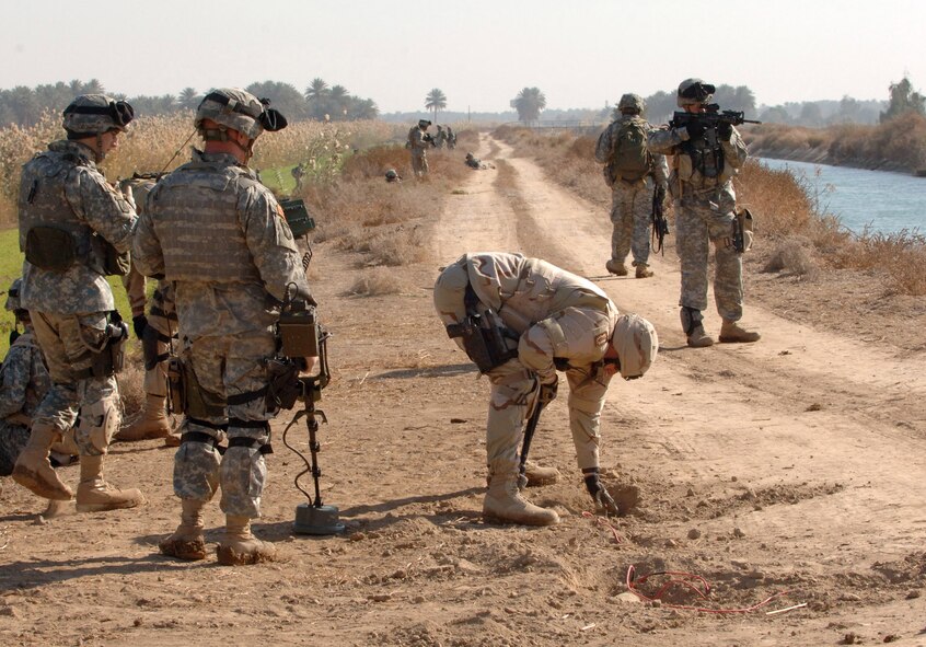 SHAKARIA, Iraq -- Capt. Joshua Tyler, center, and Tech. Sgt. Brian Schilhabel, left, secure an improvised explosive device. Soldiers from Bravo Company, 2nd Battalion, 502nd Infantry Regiment conducted the search. Captain Tyler and Sergeant Schilhabel are with the 447th Expeditionary Civil Engineer Squadron. (U.S. Army photo by Army Staff Sgt. Kevin L. Moses Sr.)