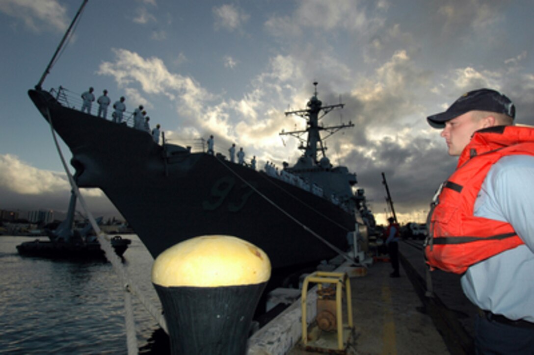 Navy Seaman Mitchell Blythe stands ready to cast off the bow line of the USS Chung-Hoon (DDG 93) as the guided missile destroyer prepares to get underway from Pearl Harbor, Hawaii, on Jan. 5, 2006. The Arleigh Burke-class is departing for a five-month deployment in support of the global war on terrorism. 