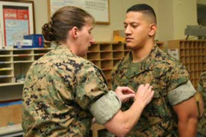 Lance Cpl. Allen G. Elisara, Headquarters and Headquarters Squadron postal clerk and native of Honolulu, is awarded the Navy and Marine Corps Achievement Medal at the Southside Post Office, July 6.