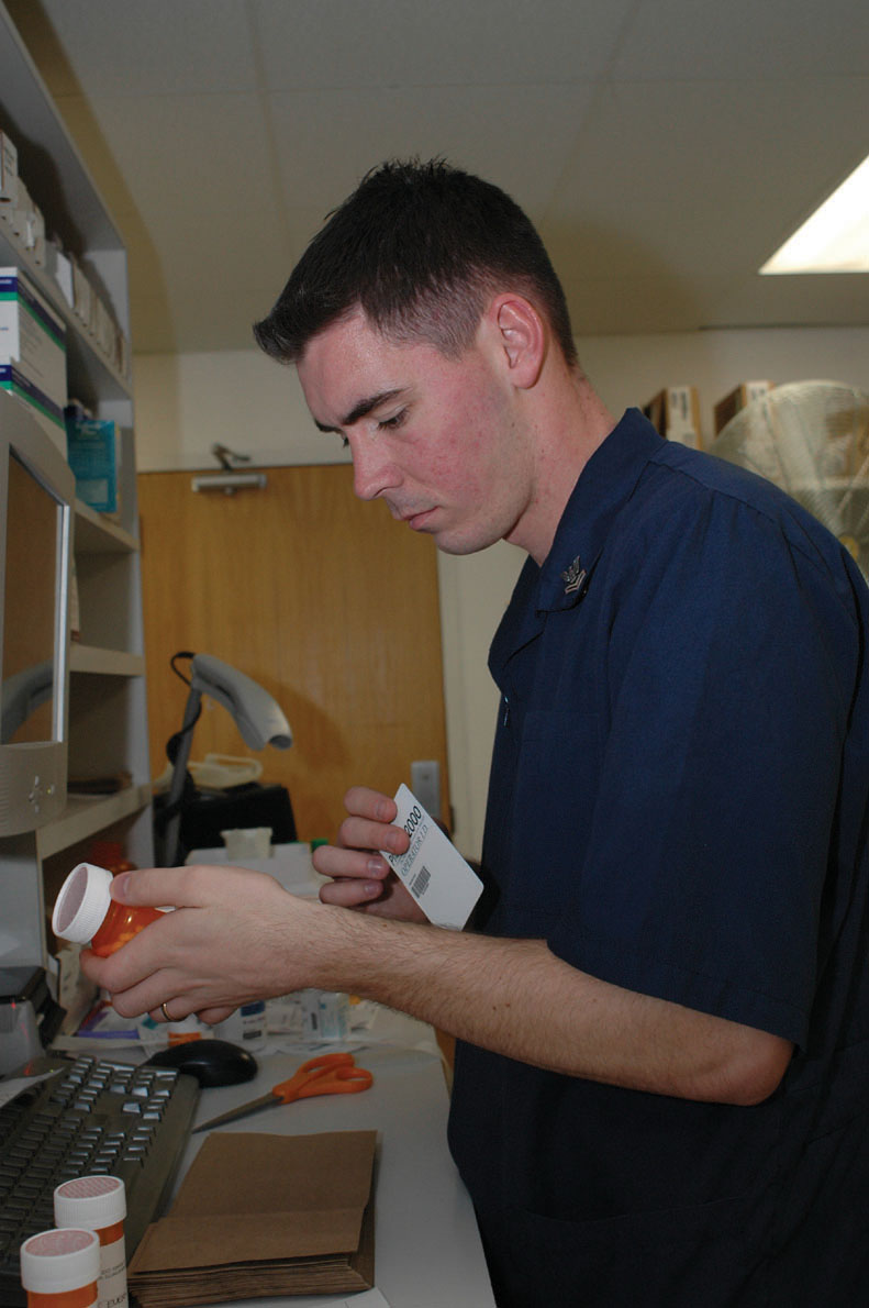 Petty Officer 2nd class Andrew Wilson, Branch Medical Clinic pharmacy technician, double checks the prescription written against the medication dispensed Jan. 6 in the BMC pharmacy. The pharmacy fills an average of 83,000 prescriptions per year, and a mistake could mean the difference between life and death for the person receiving the medication.