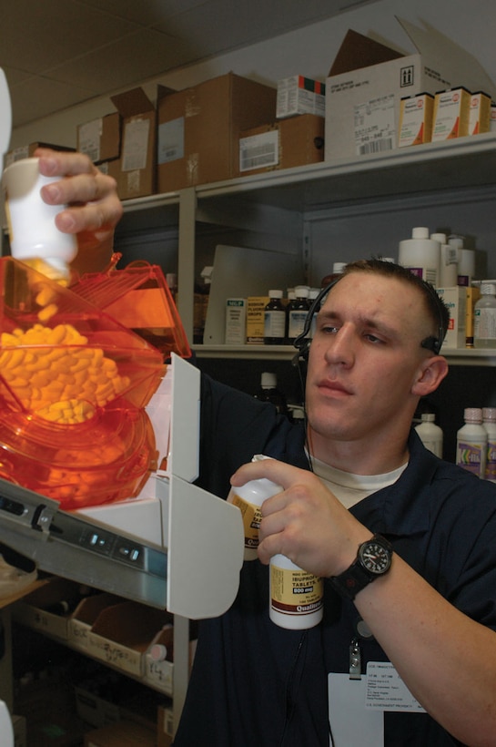 Seaman Matt Broemeling, Branch Medical Clinic pharmacy technician, refills a medication-dispensing machine Jan. 6 in the BMC pharmacy. The new machines automatically count out and dispense prescriptions, reducing the time each prescription takes to fill.