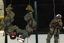 INDIAN HEAD,Md--Corporal Shane P. Czesak (left), a Crystal Lake, Ill., native reenlists during an inverted repel off a 24-foot platform at the Chemical Biological Incident Response Force (CBIRF) January 6.  Czesak, a member of the unit's Rescue platoon committed himself to four more years of active duty service in the crash fire rescue Military Occupational Specialty (MOS) because he wanted to "experience more of the Marine Corps."  "I did the repel inverted for my Marines and Chief Warrant Officer 2 Hilliard who joined the unit a few months ago," Czesak said.  "I want everyone to know what Rescue platoon is all about."  "Rescue platoon is one of the most strenuous jobs to master at this unit," said Czesak.  "We push ourselves beyond the limits and sometimes train for 72 hours non-stop with minimal sleep.  We make the training as extreme as possible so that it resembles a real-world scenario," Czesak continued.  "When something happens we want the world to call on CBIRF."