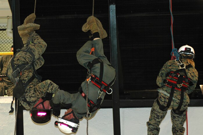 INDIAN HEAD,Md--Corporal Shane P. Czesak (left), a Crystal Lake, Ill., native reenlists during an inverted repel off a 24-foot platform at the Chemical Biological Incident Response Force (CBIRF) January 6.  Czesak, a member of the unit's Rescue platoon committed himself to four more years of active duty service in the crash fire rescue Military Occupational Specialty (MOS) because he wanted to "experience more of the Marine Corps."  "I did the repel inverted for my Marines and Chief Warrant Officer 2 Hilliard who joined the unit a few months ago," Czesak said.  "I want everyone to know what Rescue platoon is all about."  "Rescue platoon is one of the most strenuous jobs to master at this unit," said Czesak.  "We push ourselves beyond the limits and sometimes train for 72 hours non-stop with minimal sleep.  We make the training as extreme as possible so that it resembles a real-world scenario," Czesak continued.  "When something happens we want the world to call on CBIRF."