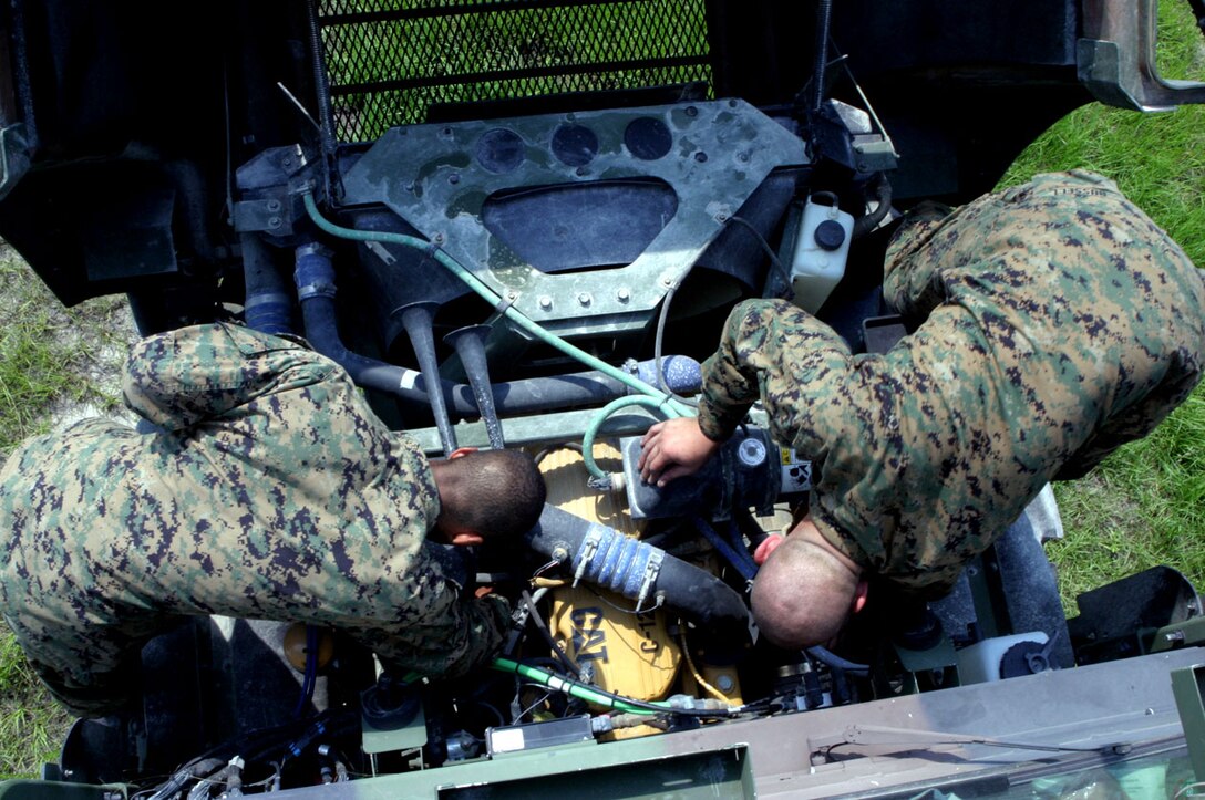 Cpl. Tyrone Williams and Pfc. Theodore K. Bussell, amtrak mechanics with 2nd Amphibious Assault Battalion, work on a vehicle?s engine during a six-day training exercise here, June 21. The Marines trained for real life situations they might come across while deployed to a forward position in Iraq.