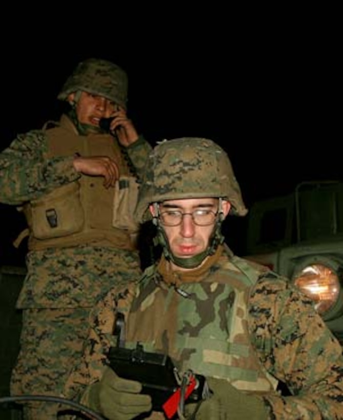 Lance Cpl. Adrian M. Negron, field radio operator, right, encrypts a frequency sequence as Cpl. Benjamin E. Escobar performs a radio check during a communication exercise at Bogue Field.